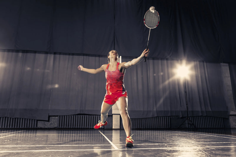 Player training on BWF-grade vinyl indoor badminton court — engineered shock absorption