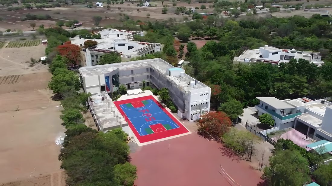 Aerial view of a finished multi-sport PP-tile court within a school campus, Sangola, Maharashtra