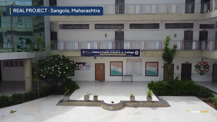Bare grey concrete courtyard at Fabtech Public School, Sangola, with the school and junior college signboard on the buil