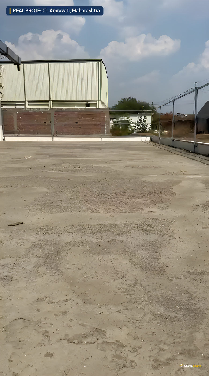 Bare unsurfaced ground at the Amravati house before base construction — a flat dusty platform bounded by the property wa