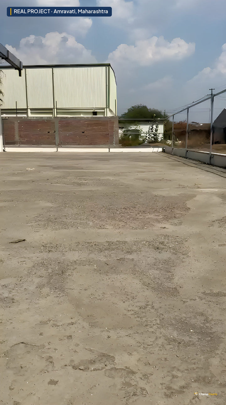 Bare unsurfaced ground at the Amravati house before base construction — a flat dusty platform bounded by the property wa