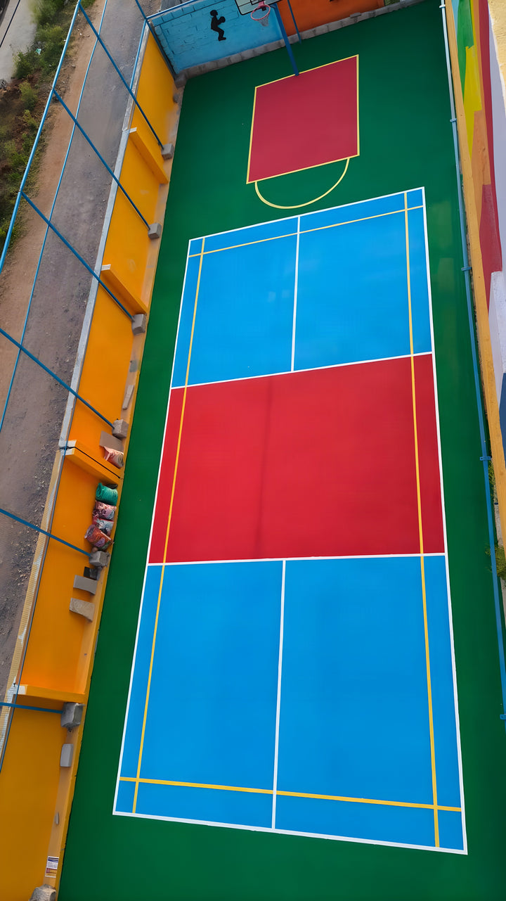 Drone aerial of the finished multi-sport acrylic court with badminton and basketball markings — ChampCourts project, Hyderabad