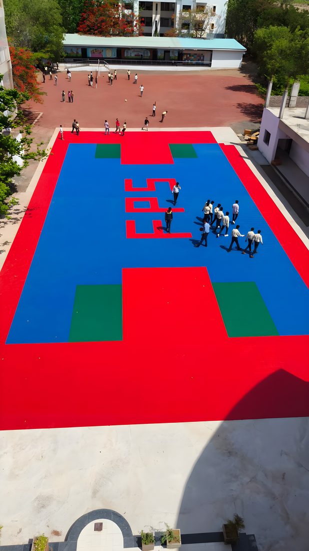 The same school courtyard after installation — finished multi-sport court in use, Sangola, Maharashtra