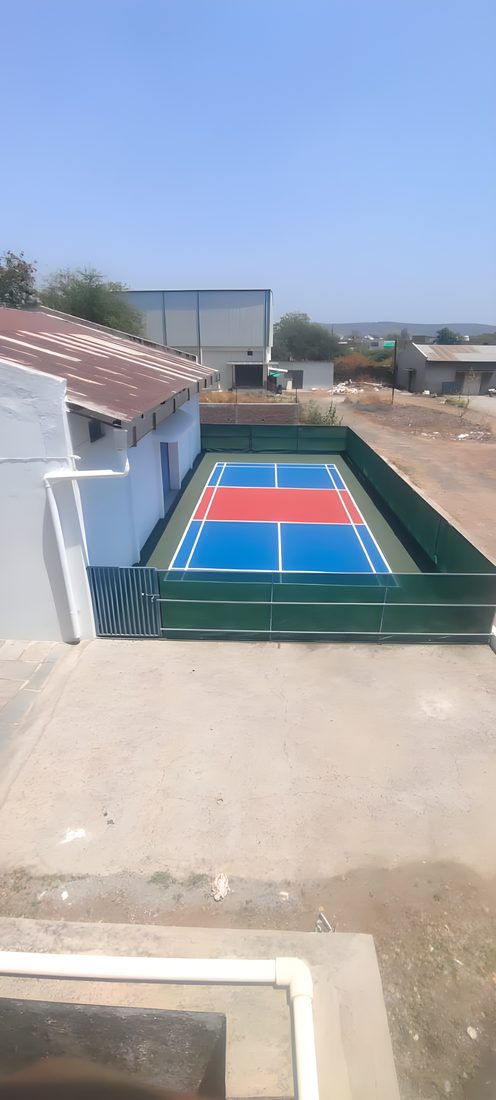 Elevated view of an enclosed private pickleball court within the property, Amravati