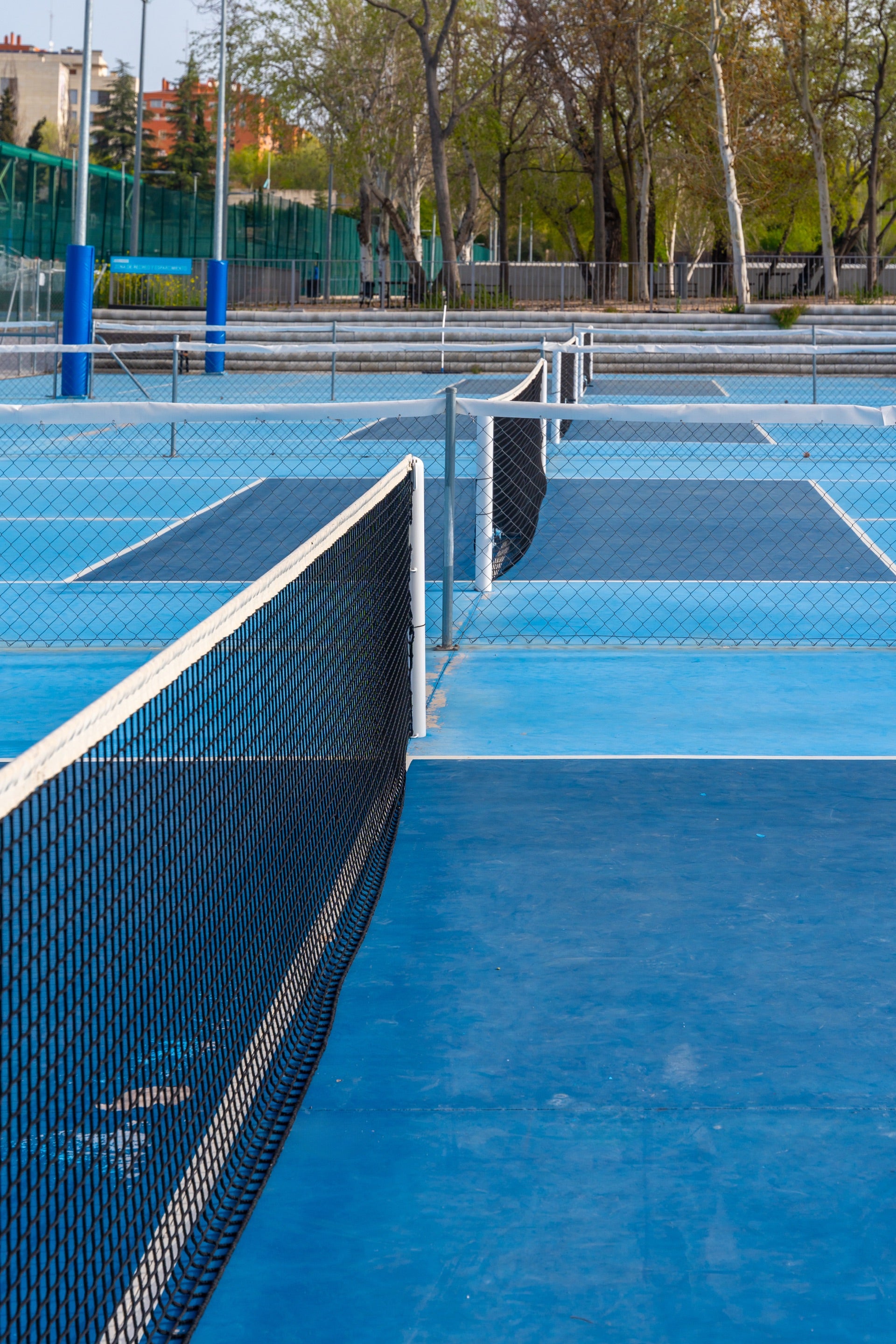 Green and Yellow PP tile pickleball court on a 22nd floor penthouse terrace with city skyline