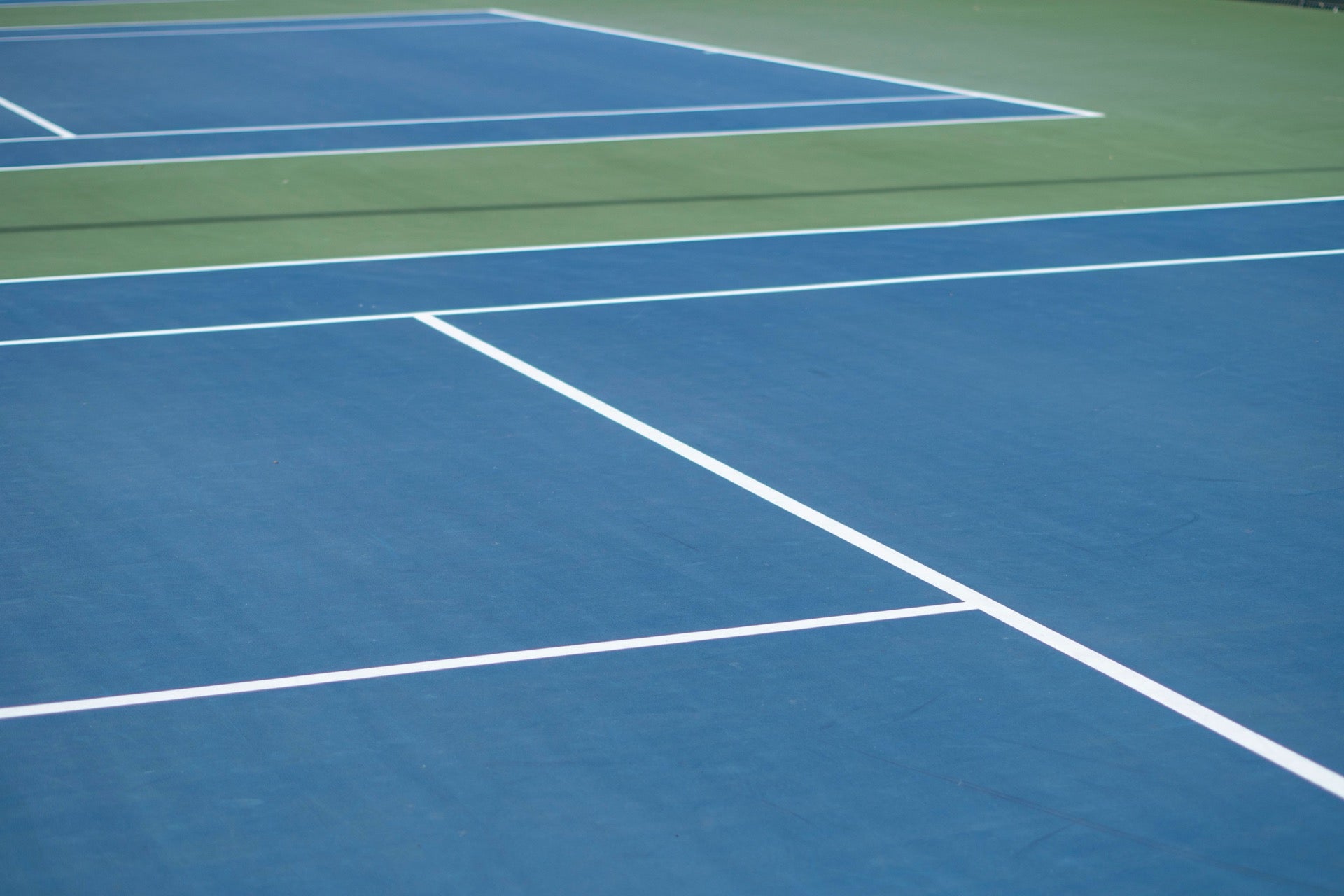Completed 8-layer acrylic tennis court in Grass Green with Dark Green border